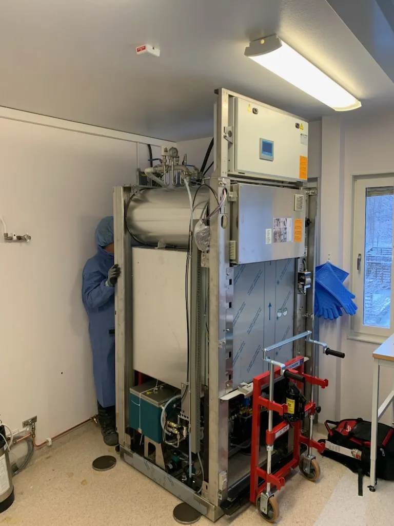 Autoklav med öppen sida där tryckkärl, rör och ventiler syns under installationen